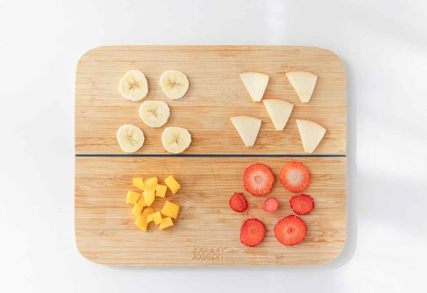 バナナ、りんご、いちご、冷凍マンゴーをカットする