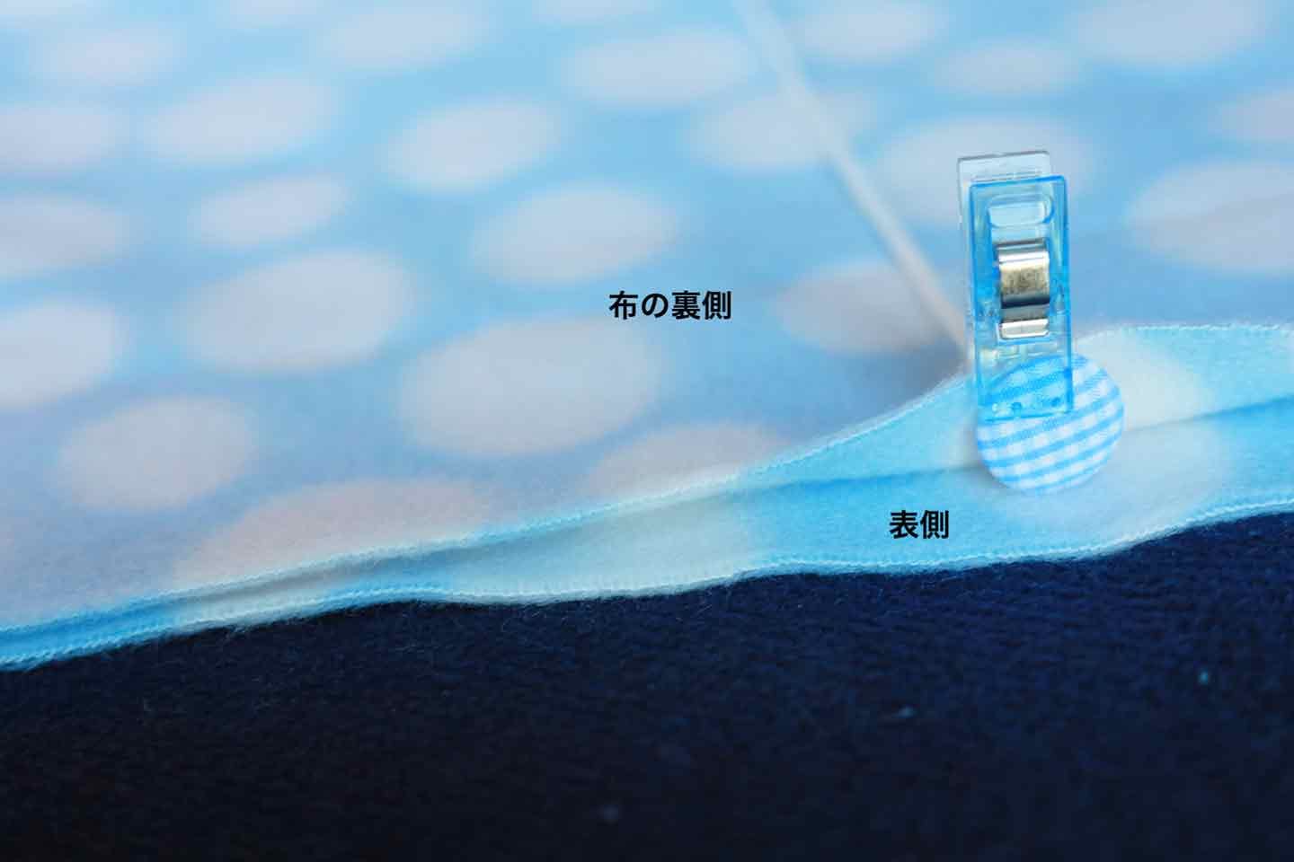 布を半分に折って、ゴムの先のボタンを内側に折り入れる