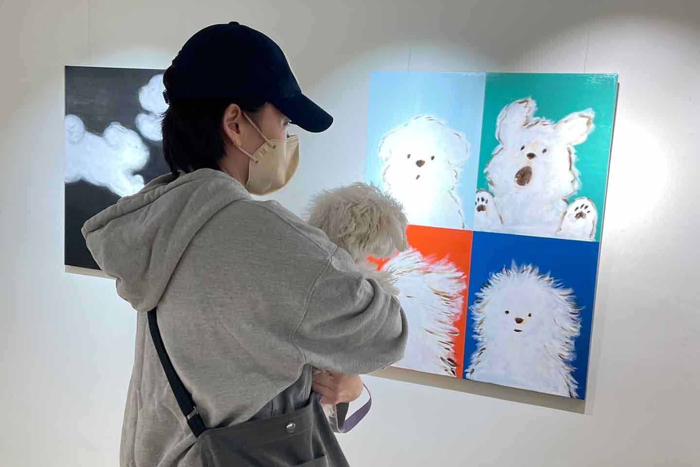 個展にて、自身が描かれたアクリル画を見つめるムンゲくん