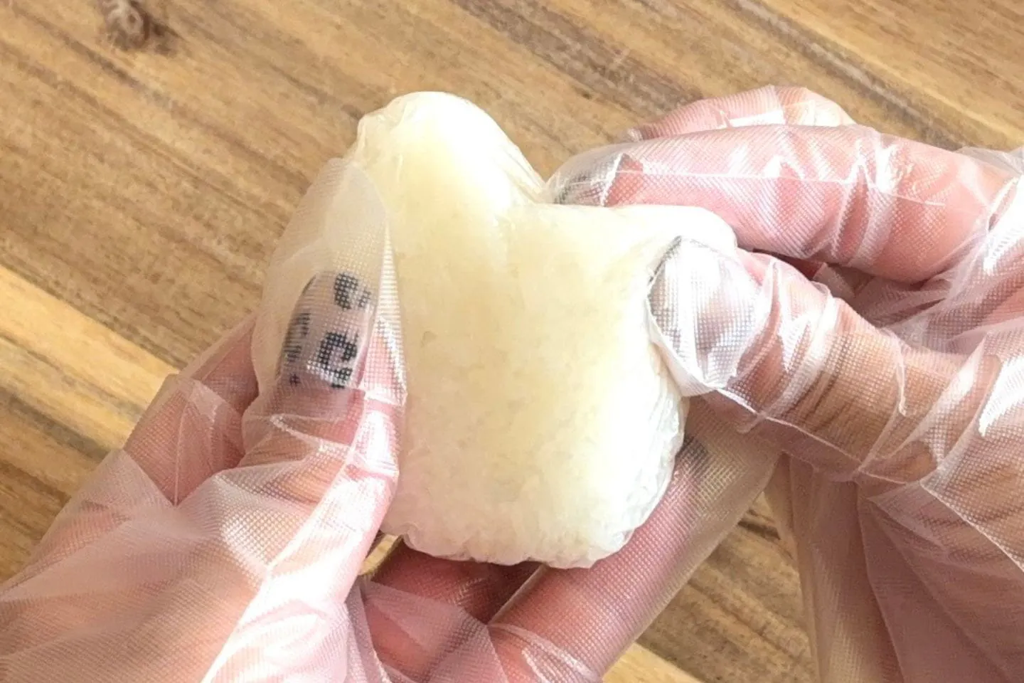 ごはんを2等分し、ラップに包んで丸く握る